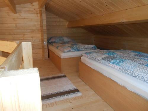 WapnicaDomek pod Świerkiem的小木屋内一间卧室,配有两张床
