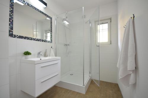 达洛科Apartamenty Mariner的白色的浴室设有水槽和淋浴。