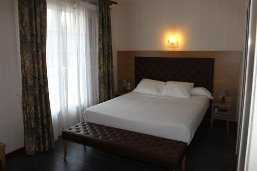 尚塞拉德艾唐雷纳酒店的一间卧室设有一张大床和一个窗户。