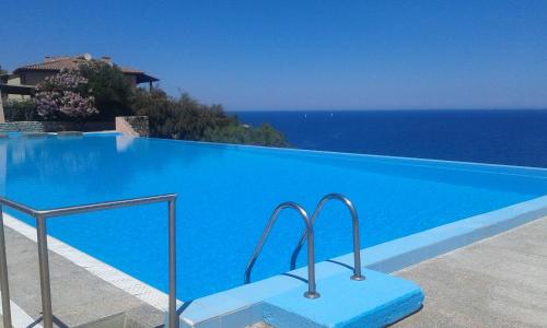罗通多港Ladumar Sardinia的蓝色的游泳池,背景是大海