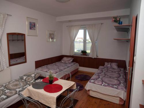 拉辛Pokoje Gościnne "Amelia"的客房设有两张床、一张桌子和一扇窗户。
