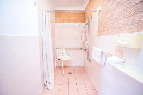 考拉Golden Chain Aalana Motor Inn的带淋浴和卫生间的白色浴室
