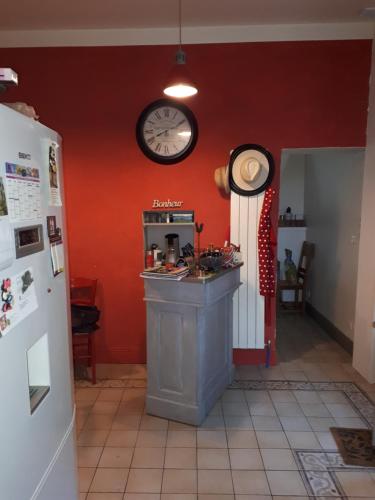 帕尔兹哈克Villa SAINT-PRIVAT的厨房配有柜台和墙上的时钟