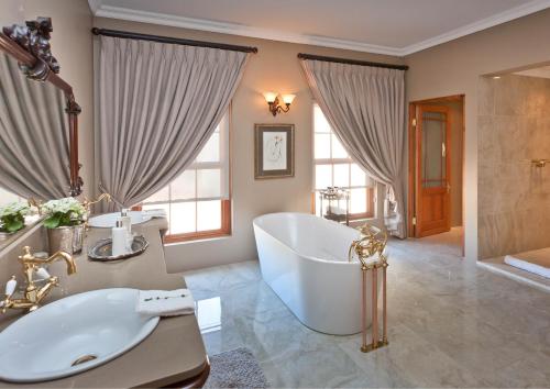 奥茨胡恩La Plume Boutique Hotel & Spa的一间带大浴缸和水槽的浴室