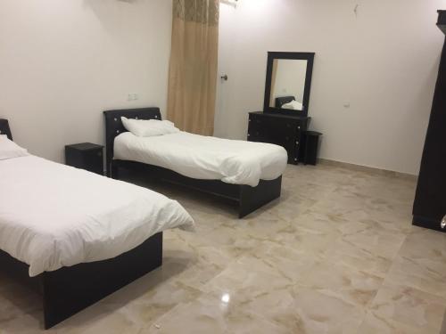 艾卜哈Al Sondos Furnished Apartments的酒店客房,设有两张床和镜子