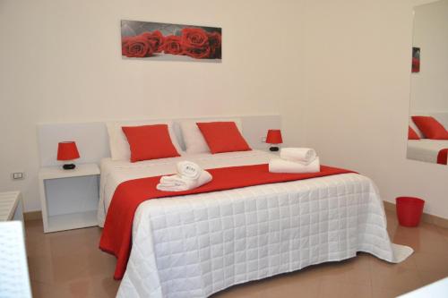 切萨雷奥港Bed Happy的一间卧室配有红色和白色枕头的床