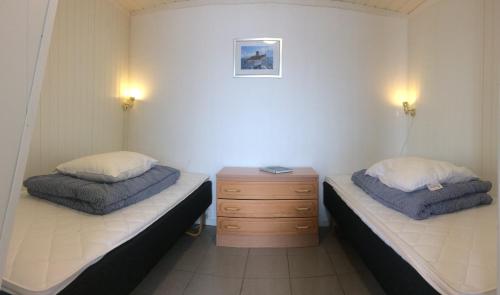 Løding阿克提科海港酒店的一间设有两张床和木制梳妆台的房间