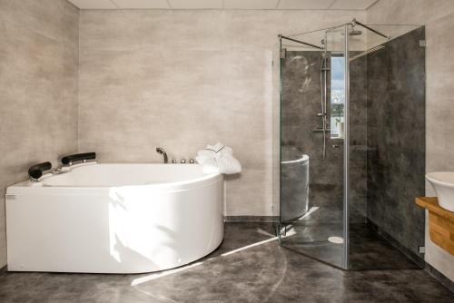 胡迪克斯瓦尔Strandpiren Hotell的一间带浴缸和淋浴的浴室