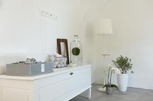 阿科Arco Dei Sogni的白色的客房设有梳妆台、镜子和植物