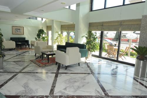 安卡拉巴哥戴酒店的大堂设有白色的椅子和桌子以及窗户。