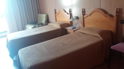 马斯萨内特德拉塞尔瓦Hostal Bonaterra的一间卧室配有两张床和椅子