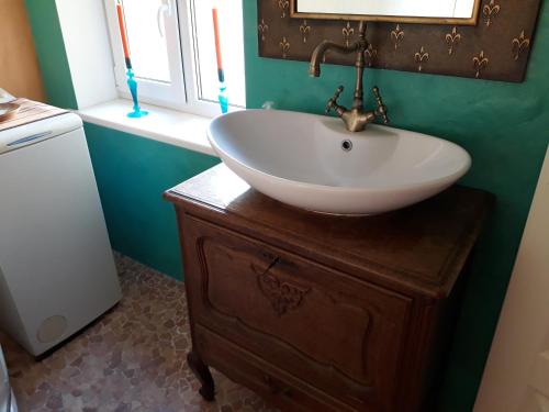 派尔努Theodori Holiday House的木质梳妆台上带白色盥洗盆的浴室