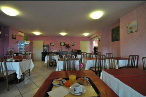 Witry-lès-Reims普里姆兰斯酒店的一间带桌椅的餐厅和一间用餐室