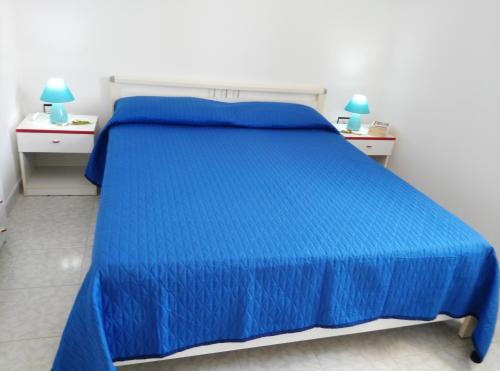 萨尔维Salento Mare Sabbioso的一张蓝色的床,房间有两个床头柜