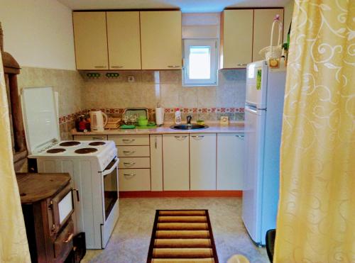 扎布利亚克Apartman Anastasija的厨房配有白色橱柜和白色冰箱。