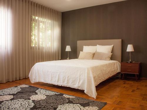 波瓦-迪瓦尔津Varzim Guesthouse的卧室配有白色的床和窗户。