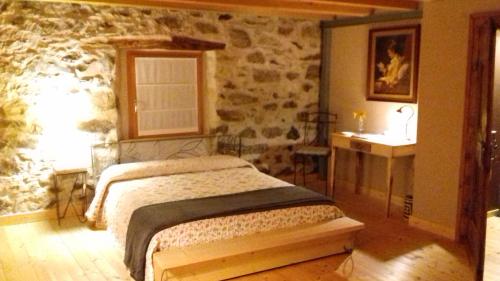 Prata CamportaccioB&B Sasso Bianco的一间卧室设有一张床和石墙