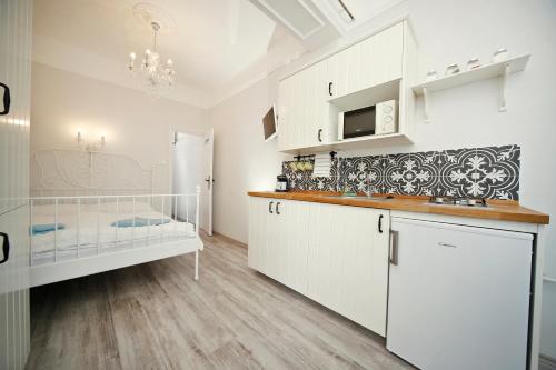 博加奇老磨坊公寓旅馆的厨房配有白色橱柜和台面