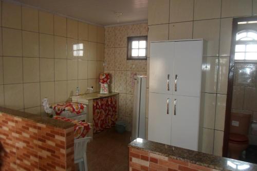 巴拉迪圣若昂Quitinetes dos Ipês的厨房配有白色冰箱和桌子