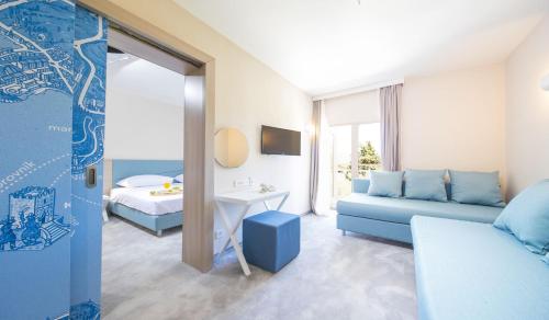 科尔丘拉Aminess Port 9 Resort的客厅配有蓝色的沙发和床。