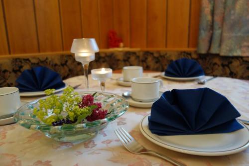 ReinsbergGästehaus Daurer的一张桌子,上面放着盘子和一碗鲜花