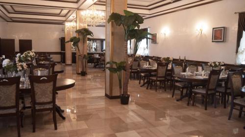 奎兹洛达Hotel KREZ的一间带桌椅和鲜花的用餐室