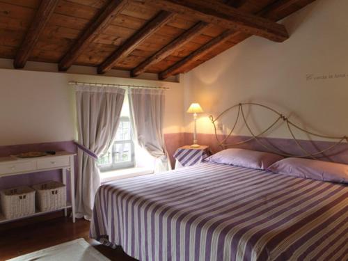 布索伦戈Agriturismo Casa Aurora的一间卧室设有一张大床和一个窗户。