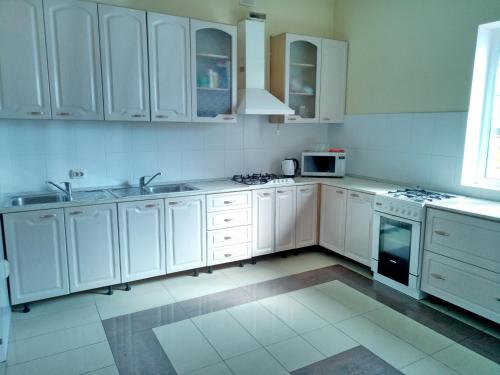 阿德勒Lime Guest House的白色的厨房配有白色橱柜和电器