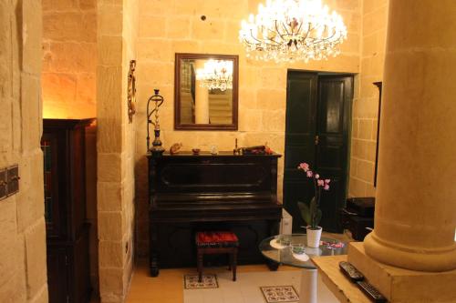 拉巴特Villa Vittoria的客厅配有钢琴和吊灯