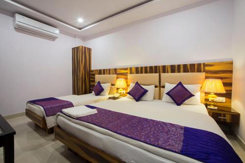 新德里Hotel Shri Vinayak at New Delhi Railway Station-By RCG Hotels的酒店客房配有两张带紫色枕头的床