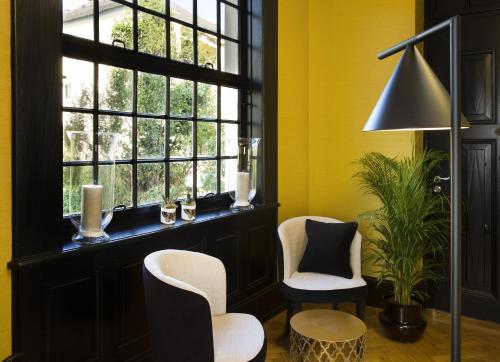 斯特拉斯堡十五号精品酒店 的黄色的房间,设有两把椅子和窗户