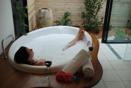 谭伯连山女巫瀑布别墅酒店的躺在浴缸里的女人,喝一杯葡萄酒