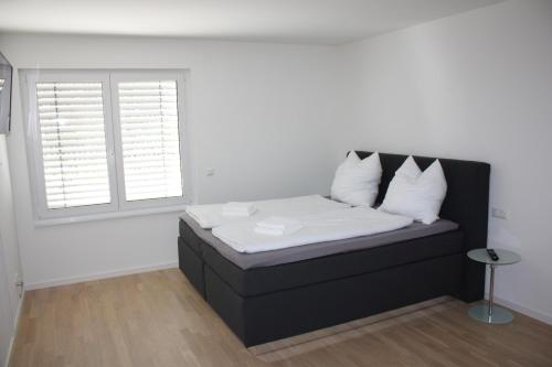 施瓦格明德Salvatorferienwohnung的一张黑色的床,配有白色床单和枕头