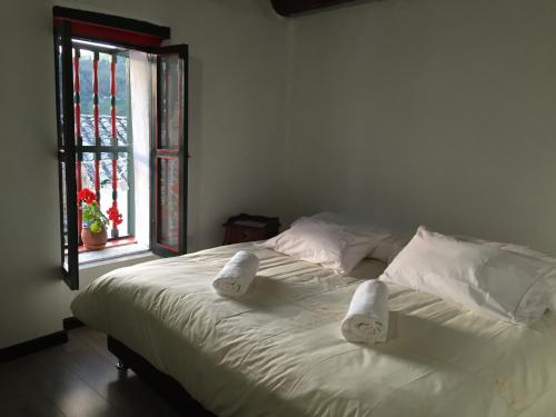 蒙圭Hotel Otti Colonial的一张带白色床单和枕头的床以及窗户