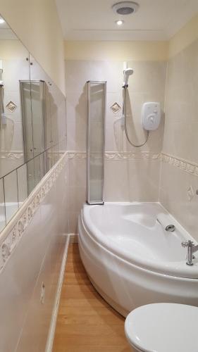 法尔茅斯Cotswold House的带淋浴和盥洗盆的白色浴室