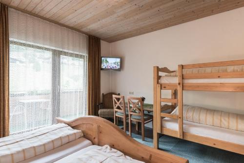 海利根布卢特鲍尔勒旅馆的一间卧室设有两张双层床和一张桌子