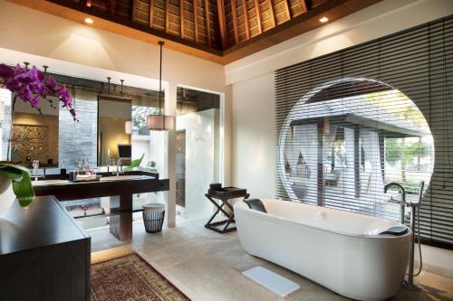 努沙杜瓦皇家珊特瑞安酒店的带浴缸和盥洗盆的浴室以及书桌。