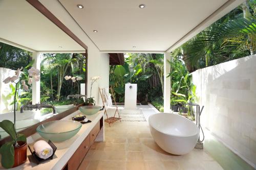 塞米亚克巴厘阿斯里别墅酒店的一间带两个盥洗盆的浴室和一个大窗户