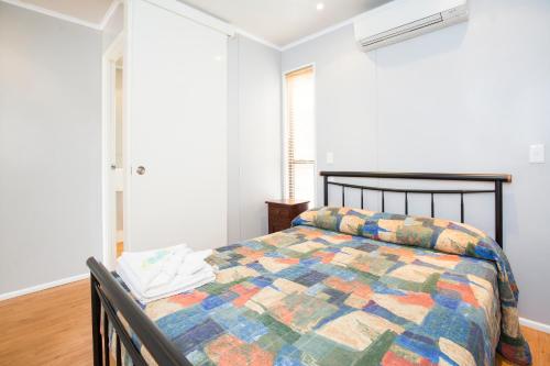 汤斯维尔Townsville Lakes Holiday Park的一间卧室配有一张带五颜六色被子的床