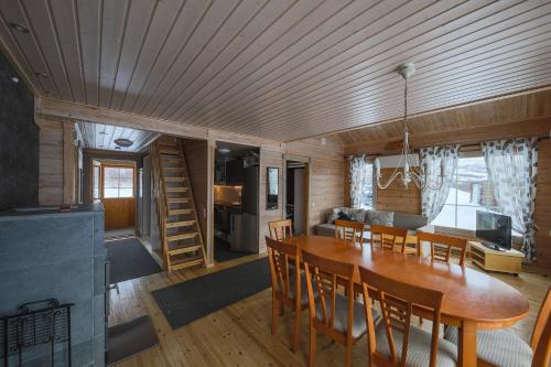 NuorgamArctic Aurora Borealis cottages的用餐室以及带桌椅的起居室。