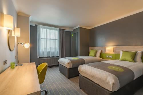 卢顿Thistle Express London Luton的酒店客房配有两张床和一张书桌
