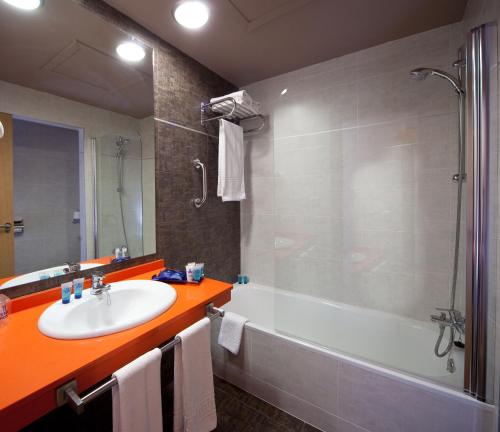 滨海罗克塔斯埃文尼亚索莱达花园酒店的带浴缸、水槽和淋浴的浴室