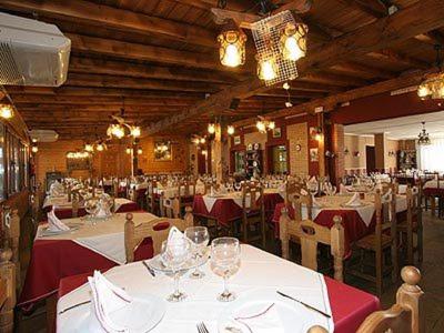 伊斯拉Hosteria San Emeterio的一间用餐室,配有白色的桌椅和红色的桌布