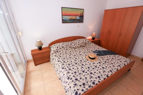 克勒克Apartments Gabrijela - Villa Komarna的一间卧室,配有一张床,上面有帽子