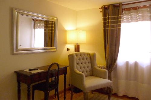别尔萨Hostal Vidaller旅馆的客房配有书桌、椅子和灯具