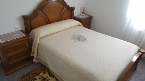 QueijadoiroCasa de Forno的一张带木制床头板和床头柜的床