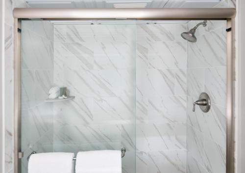 查尔斯顿谢姆河酒店的浴室设有白色大理石瓷砖和淋浴。