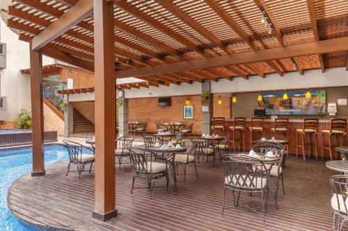 危地马拉巴塞罗危地马拉城酒店的一个带桌椅的庭院和一间酒吧