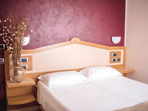 卡斯特拉纳格罗泰葛瑞夫公园酒店的卧室配有白色床和紫色墙壁