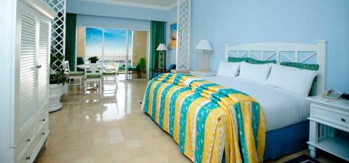 卡波圣卢卡斯Suites at PB Rose' Resort and Spa Cabo San Lucas的一间带大床的卧室和一间客厅